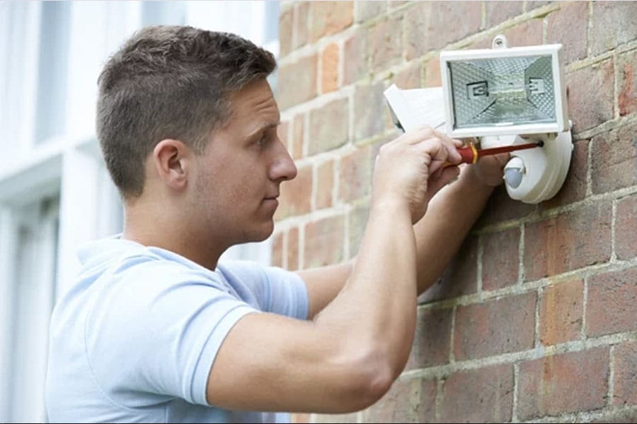 REF electrician installing outdoor lighting as part of our electrical services