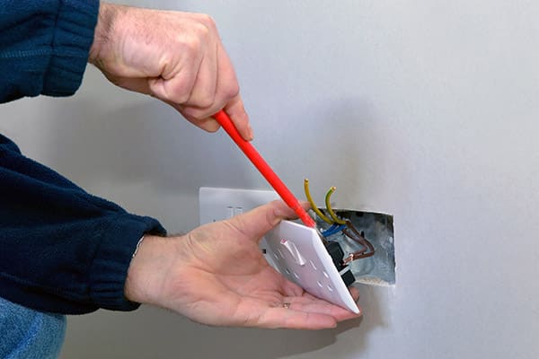 A REF domestic electrician installing a plug socket